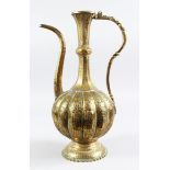 A 19TH CENTURY ISLAMIC CAIRO WARE HAND CHISLED BRASS EWER, 36cm high.