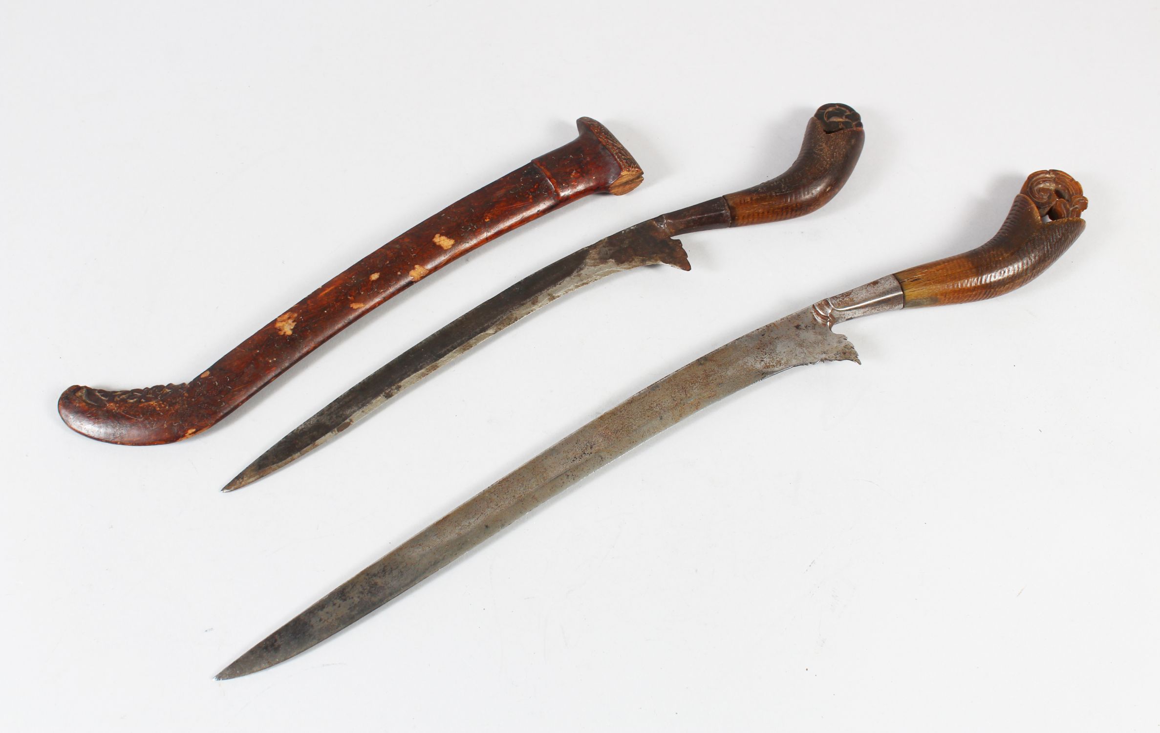 TWO 18TH-19TH CENTURY MALAYSIAN DAGGERS, one with rhino carved handle, 40cm long.