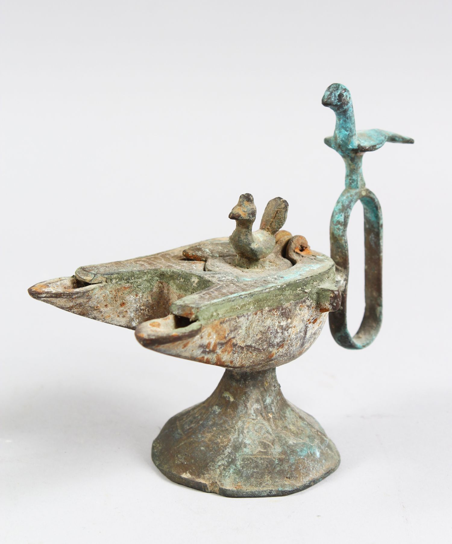 A 12TH CENTURY SELJUK BRONZE OIL LAMP with two bird finials, 12cm high.