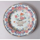 A CHINESE YONGZHENG FAMILLE ROSE PORCELAIN PLATE, decorated profusely with scrolling vine and flora,