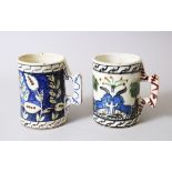 TWO IZNIK STYLE POTTERY TANKARDS, 13cm high.