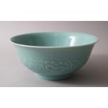 A LARGE CHINESE CELADON GROUND PORCELAIN BOWL WITH MOULDED FLORAL DECORATION, the base bearing a six