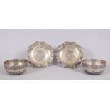 A PAIR OF EASTERN SILVER CIRCULAR BOWLS, 11cm diameter with a pair of dishes 14cm diameter.