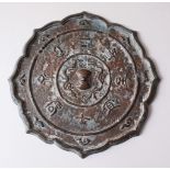A GOOD CHINESE BRONZE SCALLOPED MING MIRROR, with decorated character marks surrounding the