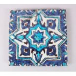 AN EARLY 16TH CENTURY IZNIK POTTERY BLUE AND WHITE TILE, 'a.f.', 23cm square.