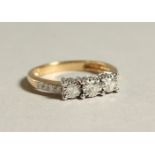 A 9CT GOLD THREE STONE DIAMOND RING.