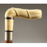 A WALKING STICK, with carved bone handle. 89cms long.