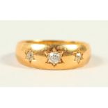 AN 18CT GOLD AND THREE STONE DIAMOND RING.
