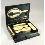 A LATE VICTORIAN IVORINE DRESSING TABLE SET, monogrammed, in a fitted case.