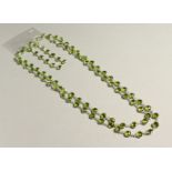 A SILVER AND PERIDOT SET LONG GUARD CHAIN AND EARRINGS.