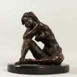 AN ABSTRACT BRONZE OF A SEATED FEMALE NUDE, on an oval marble base. 27cms high.