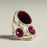 A SILVER THREE STONE AMETHYST RING.