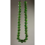AN EARLY GREEN GLASS "TRADE" BEAD NECKLACE. 80cms long.