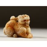 A CARVED WHITE JADE DOG OF FO. 8cms long.