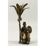 A VIENNA STYLE COLD PAINTED BRONZE, of a man with sword and shield seated beneath a palm tree. 25cms