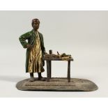 A VIENNA STYLE COLD PAINTED BRONZE, of a man standing beside a table with books. 16cms wide.