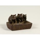 A SMALL BRONZE GROUP OF PIGS AT A TROUGH. 4.5cms wide.