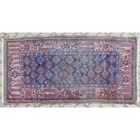 A PERSIAN RUG, blue ground with stylised decoration. 174cm x 92cm.