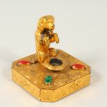 A GOOD SMALL GILT METAL STAND, modelled as a begging dog by a hat, the base with engraved decoration