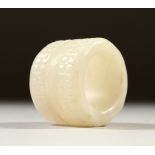 A WHITE JADE ARCHERS RING. 3cms wide.