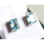 A PAIR OF EMERALD CUT BLUE TOPAZ CLUSTER EARRINGS.