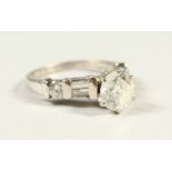A PLATINUM MOUNTED DIAMOND RING, the central stone of 1.5cts flanked by baguette diamond