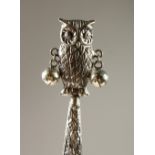 A SILVER OWL AND MOTHER-OF-PEARL BABIES RATTLE.