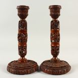 A SUPERB PAIR OF 18TH CENTURY CARVED AND PIERCED CANDLESTICKS, on circular bases, carved with a