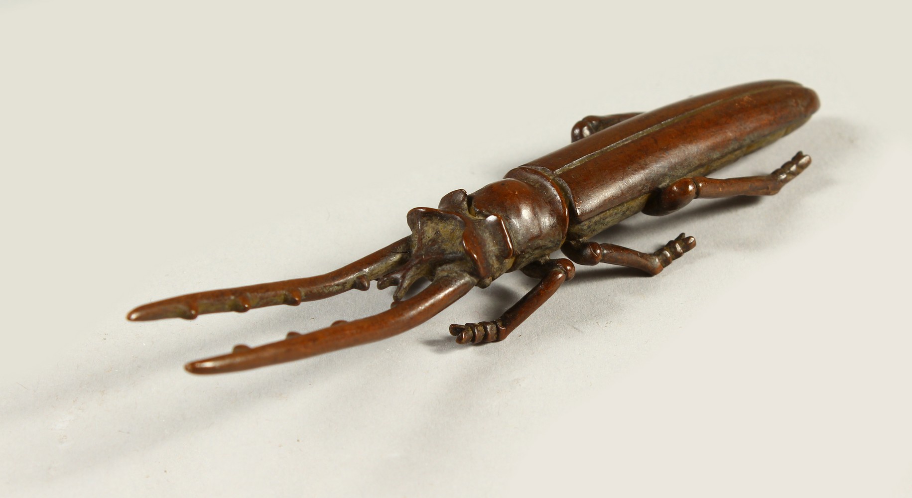 A BRONZE MODEL OF A STAG BEETLE. 13cms long.