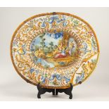 A LARGE MAJOLICA OVAL PLATTER, decorated with cupids and scrolls in relief. Bears Signature. (