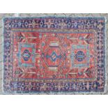 A PERSIAN RUG, red ground with three large medallions. 185cm x 137cm.