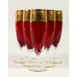 A SET OF SIX TALL STEM, RED AND GOLD CHAMPAGNE GLASSES.