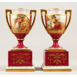 A SMALL PAIR OF VIENNA TWO-HANDLED URNS ON STANDS, painted with panels of classical figures, on