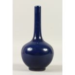 A SMALL BLUE GLAZED BOTTLE VASE. 23cms high.