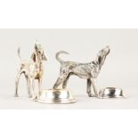 A PAIR OF NOVELTY TABLE SALTS, modelled as a dog stood beside a bowl. 12cms wide.