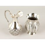 A CONTINENTAL SILVER EWER, with flower head and leaf embossed decoration; together with a silver