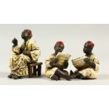 A GROUP OF THREE VIENNA STYLE COLD PAINTED BRONZE FIGURES, of seated Arab men. 7cms high.