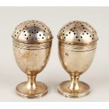 A PAIR OF SILVER PEDESTAL PEPPERETTES.