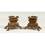 A GOOD PAIR OF 19TH CENTURY FRENCH ORMOLU VASE STANDS on claw feet. 10cms high.