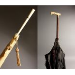 AN ART DECO IVORY HANDLED PARASOL, 91cms long and AN EDWARDIAN IVORY HANDLED PARASOL, 83cms long.