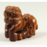 A CARVED WOOD NETSUKE OF A TEMPLE LION. 4cms long.