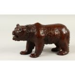 A BLACK FOREST CARVED WOOD STANDING BEAR. 28cms long.