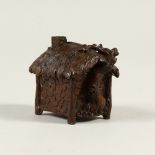 A BRONZE MINIATURE MODEL OF A HOUSE. 6cms wide.