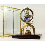 A MODERN BRASS SKELETON CLOCK, with moonphase movement, in a glass case. 53cms high.