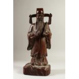 A CARVED WOOD FIGURE, of a standing sage. 43cms high.