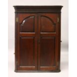 A 19TH CENTURY OAK HANGING CORNER CUPBOARD, with a pair of panelled doors enclosing three shelves.