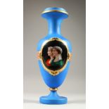 A VICTORIAN BLUE OPAQUE GLASS VASE, with a panel decorated with two female busts. 37cm high.