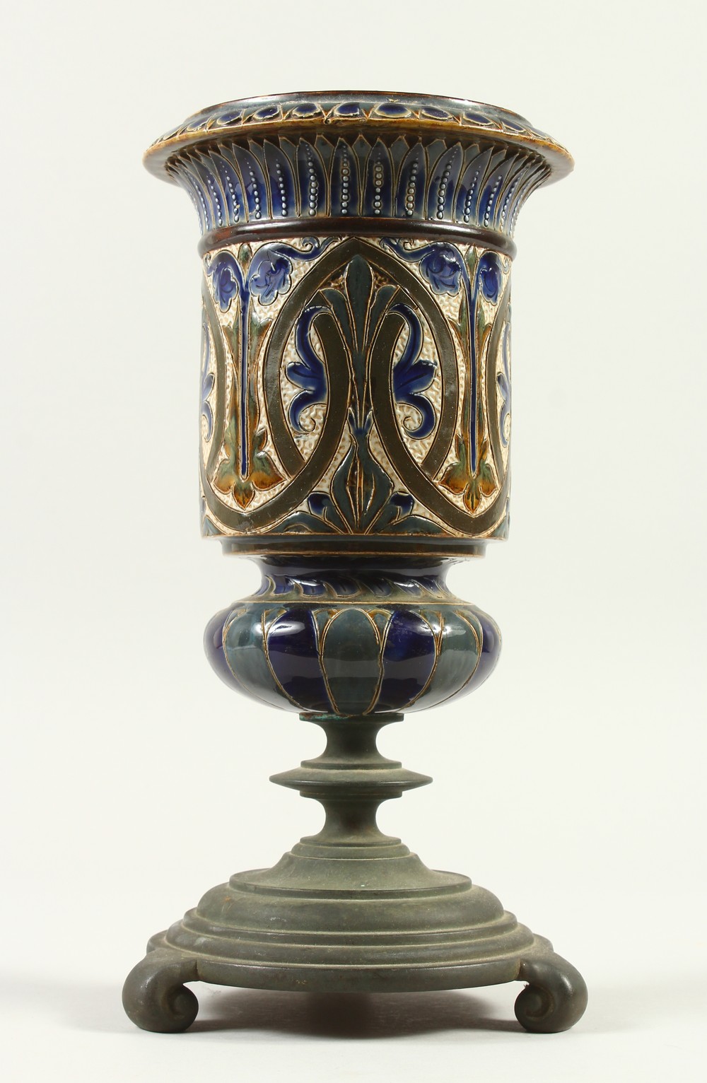 A DOULTON LAMBETH STONEWARE VASE, on a cast iron stand. 33cm high.