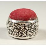 A SILVER CIRCULAR BIRD PATTERN HAT PIN HOLDER CUSHION.