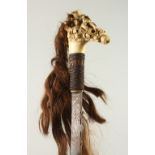 AN AFRICAN BONE HANDLED RACQUET mounted with human hair. 67cms long.